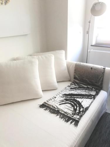 a white couch with white pillows and a rug on it at Les lofts de Styliste in Brussels