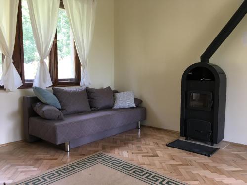 a living room with a couch and a wood stove at Csillagkert Vendégház in Kaposszerdahely