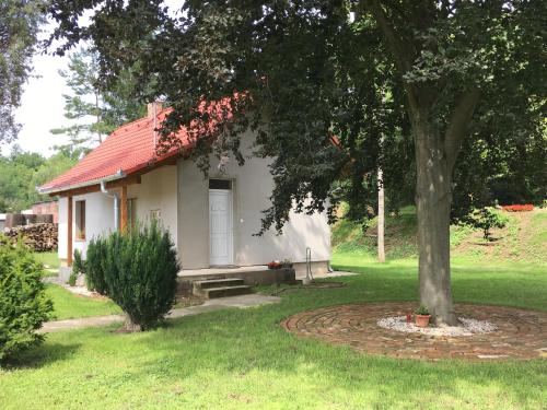 a small white house with a red roof at Csillagkert Vendégház in Kaposszerdahely