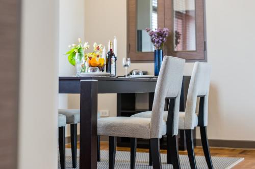 a dining room table with two chairs and a table with candles at Asoke Residence Sukhumvit by UHG in Bangkok