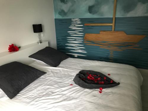 a bedroom with a bed with a painting of a boat at Les Bleuets - Erdivines in Erdeven