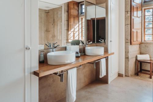 a bathroom with two sinks on a wooden counter at Pazo da Touza in Nigrán