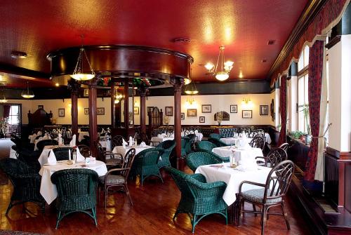 un comedor con mesas blancas y sillas verdes en Jembo Park Hotel, en Jena