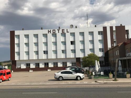 un hotel con coches aparcados delante en Hotel Buenos Aires, en Villafría de Burgos