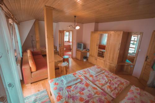 a bedroom with a bed and a living room at Penzión Weinerovka Varín in Žilina