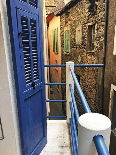 a blue door on a balcony of a building at Maison Authentique Proche Isola 2000 et Auron in Isola