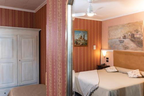 a bedroom with a bed and a painting on the wall at Holiday Rooms Antica Badia in Volterra