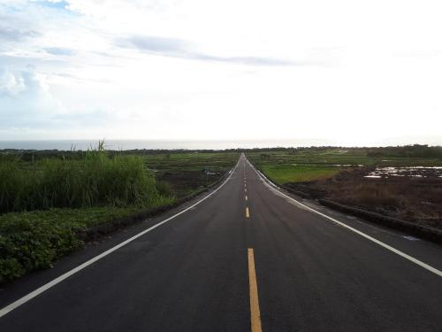an empty road in the middle of a field at Xiao Guilin Homestay in Changbin