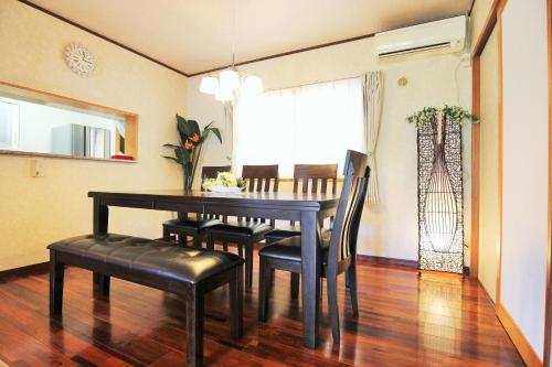a dining room with a table and chairs and a window at Resort Villa The ReLa Inn in Onna