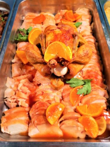 a tray of food with chicken and orange slices at Grenada Hotel in Sunny Beach