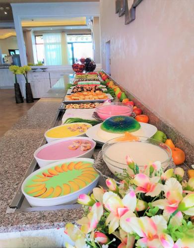 a buffet line of plates of food on a counter at Grenada Hotel in Sunny Beach