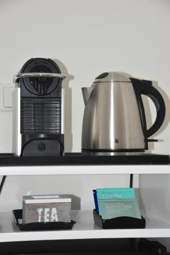 a coffee maker and a tea kettle on a shelf at Boutique Hotel Villa Monika in Westerland (Sylt)