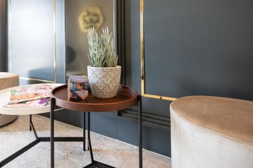 a table with a vase on it next to a stool at Arthotel ANA Aura in Aystetten