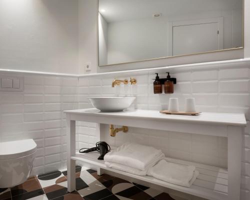a white bathroom with a sink and a toilet at Alta House Begur in Begur