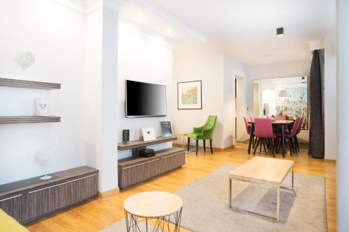 a living room with a tv and a table and chairs at Feel Belgrade Apartments in Belgrade