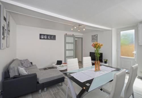 a dining room and living room with a table and chairs at Le Franche Comté Centre Ville Rive Droite in Laval