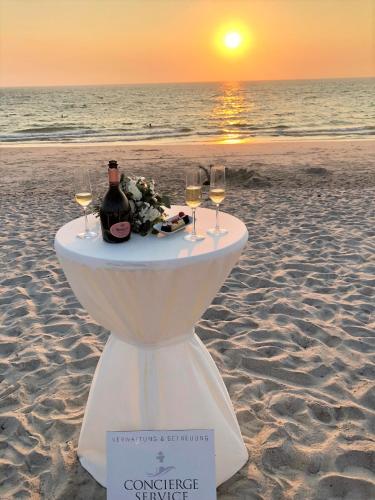 a table with wine glasses and flowers on the beach at Boutique Hotel Villa Monika in Westerland (Sylt)