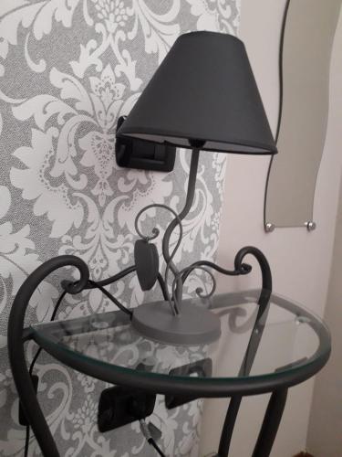 a lamp on a glass table in front of a wall at Società Agricola F.lli Angelucci in Cannara