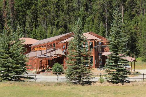 a large log cabin with trees in front of it at The Lodge at Lolo Hot Springs in Lolo