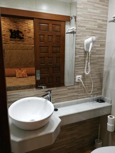 a bathroom with a large white sink and a toilet at Hostal Maestre in Córdoba