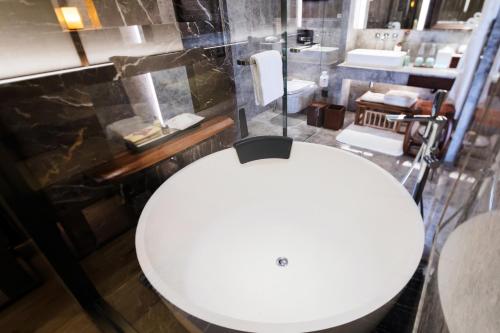a bathroom with a white sink and a toilet at The Anandi Hotel and SPA - Luxury Healing Hotel for Wellbeing in Shanghai