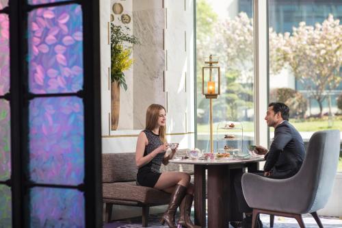 a man and woman sitting at a table in a restaurant at The Anandi Hotel and SPA - Luxury Healing Hotel for Wellbeing in Shanghai