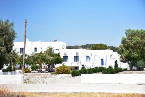 a white building with trees in front of it at Kiotari Beach Apartments in Kiotari