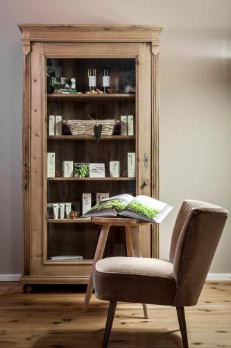 a table and a chair with a book on it at Hotel Drumlerhof in Campo Tures