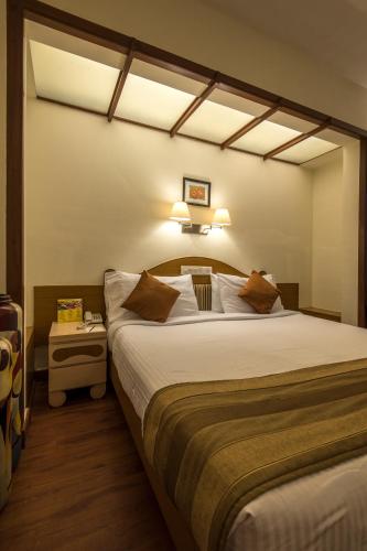 a bedroom with a large bed in a room at Hotel Park Central Koregaon Park in Pune