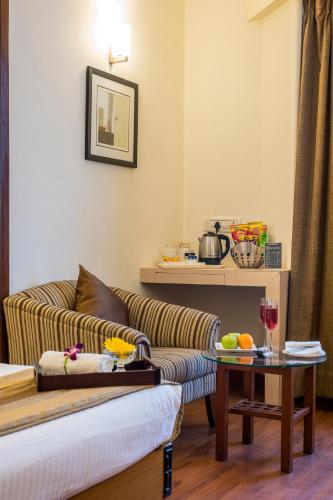 a living room with a couch and a table at Hotel Park Central Koregaon Park in Pune