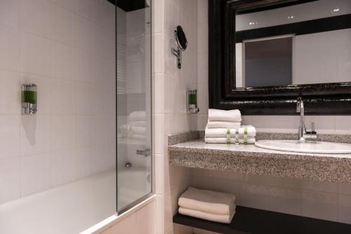 La salle de bains est pourvue d'une douche, d'un lavabo et d'un miroir. dans l'établissement Hotel Villa Nicolo, à Paris