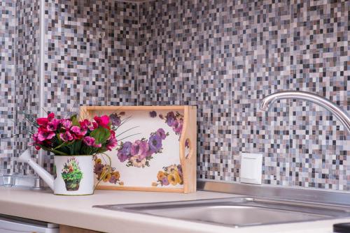a vase of flowers sitting on a counter next to a sink at Villa Ermioni Apartments in Limenaria