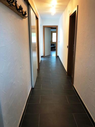 a hallway of an office building with a tile floor at Haus Willibald in Saalbach Hinterglemm