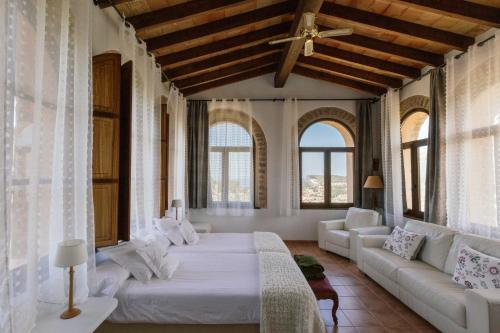een slaapkamer met een bed, een bank en ramen bij Agroturismo Muleta de Ca S'hereu in Port de Soller