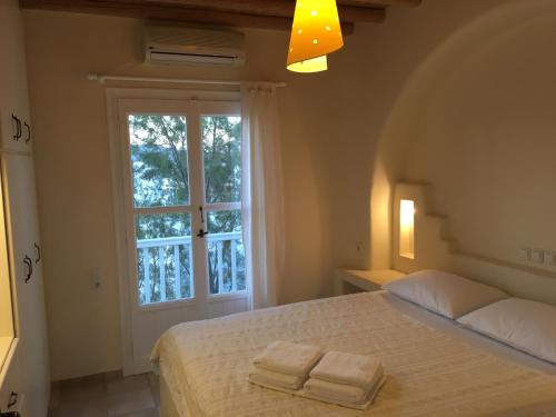 a bedroom with a bed with two towels on it at GKMykonos in Ano Mera