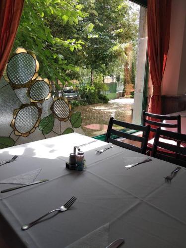 a table with a white table cloth and forks and knives at Hotel Nap in Budapest