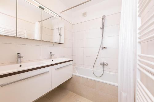 La salle de bains blanche est pourvue d'une douche et d'un lavabo. dans l'établissement Ferienwohnung Haus Zyka, à Neustift im Stubaital