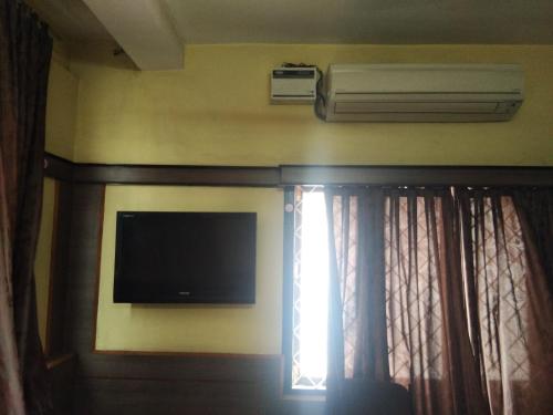 ティルチラーパッリにあるSri Saraswathi Lodgeのベッドルームの壁に薄型テレビが付いています。