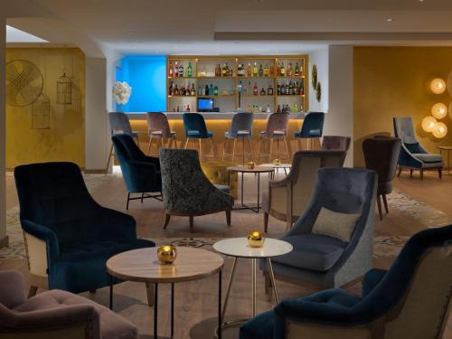 a waiting room with chairs and tables and a bar at H10 Ocean Dunas - Adults Only in Corralejo