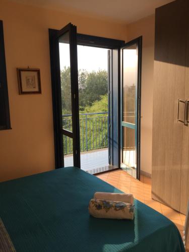 Schlafzimmer mit einem Bett und einer Tür zu einem Balkon in der Unterkunft Valentina Holiday House in Mascali