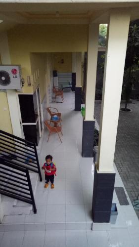 a little boy standing on the porch of a house at ZONA Homestay in Selong