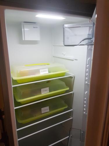 een open koelkast met groene en gele bakken bij Pension Ratsgasse in Weißensee