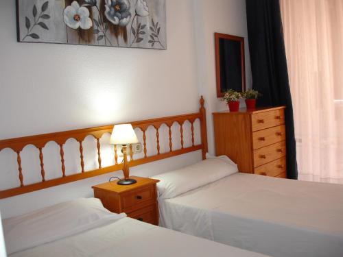 a bedroom with two beds and a lamp and a dresser at Loix Mar - Zand Properties in Benidorm