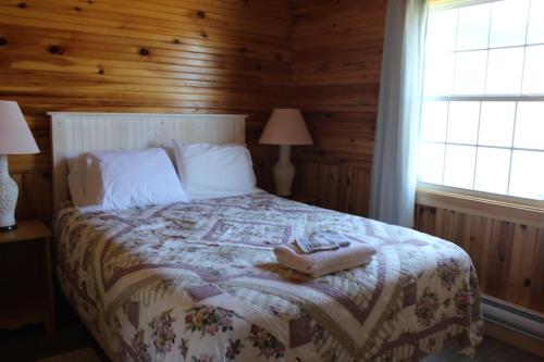 a bedroom with a bed with two shoes on it at Chalets Grand Pre Cottages in North Rustico