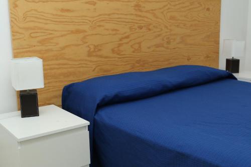a bedroom with a blue bed and two night stands at Rocca dei tramonti in Punta Braccetto