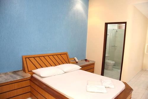 1 dormitorio con 1 cama y baño con aseo en Motel Passport, en Guaratinguetá