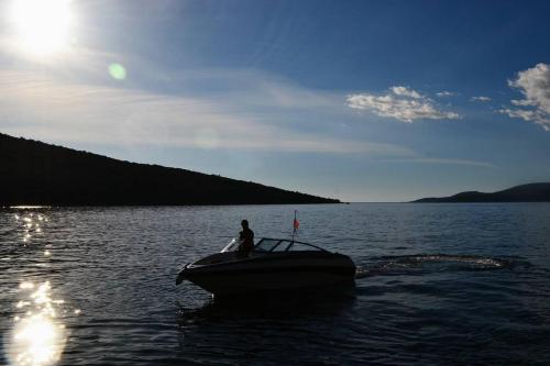 a man on a boat in the water at Sea Oasis Apartments - Milosevic in Kotor