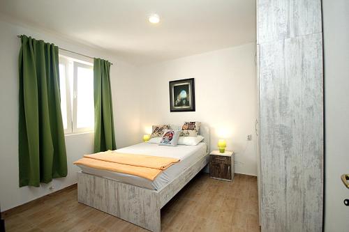 a bedroom with a bed with green curtains at Apartments Mirko in Ulcinj