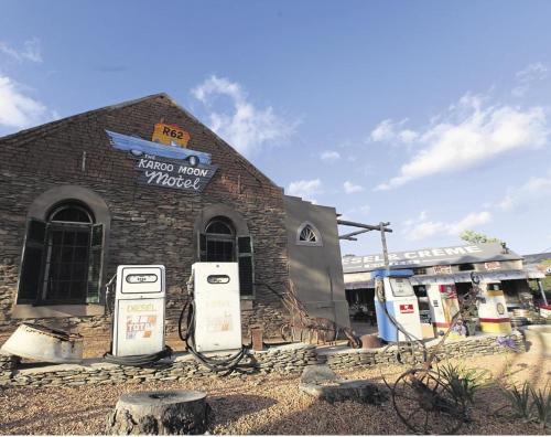 a brick building with two gas pumps in front of it at The Karoo Moon Motel in Barrydale