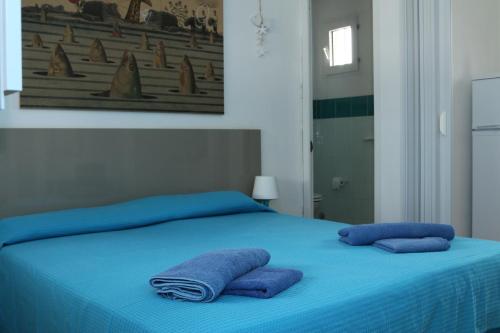 a blue bed with two towels on top of it at Rocca dei tramonti in Punta Braccetto